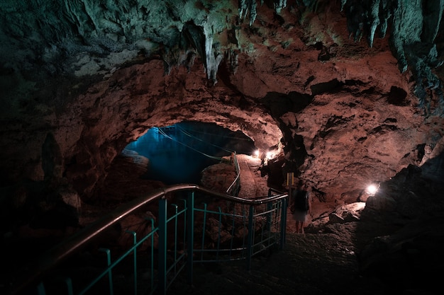 Licht fällt in die Dunkelheit einer untergetauchten Höhle mit blauem See