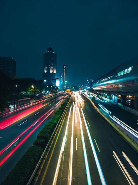 Lichtspuren auf der Straße zwischen Gebäuden in der Stadt in der Nacht