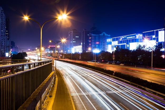 Lichtspuren auf einer Stadtstraße gegen einen klaren Himmel in der Nacht