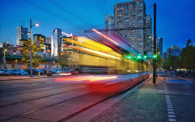 Foto lichtspuren auf straßen inmitten von gebäuden in der stadt bei nacht