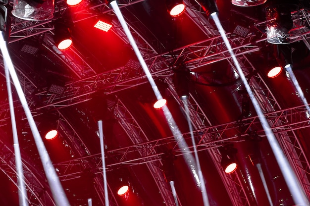 Lichtstrahlen von der Konzertbeleuchtung auf einem dunklen Hintergrund über dem Projektionsschirm.