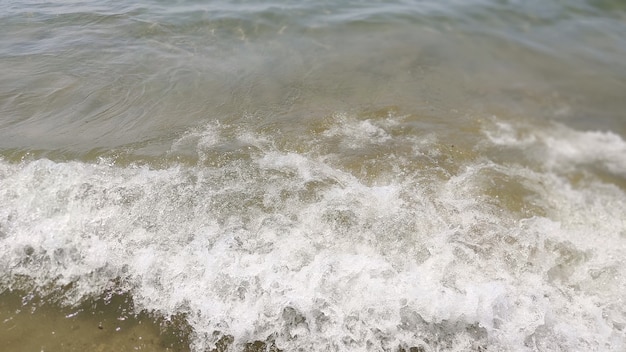 Lichtwelle auf Sand des Meeresstrandes, Nahaufnahme