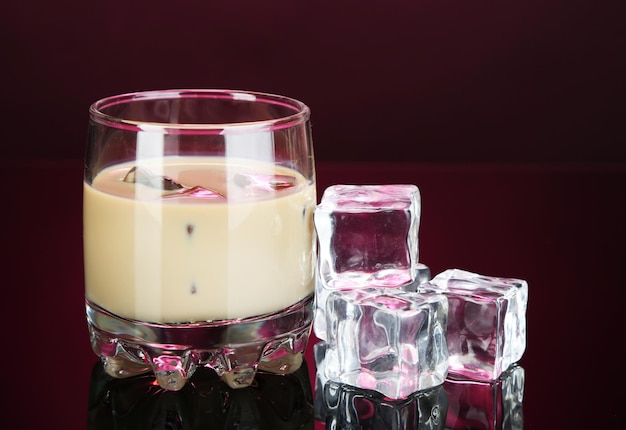 Licor Baileys en vaso sobre fondo rosa