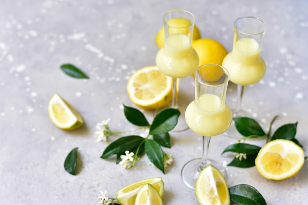 Foto licor italiano tradicional limoncello con limones y crema.