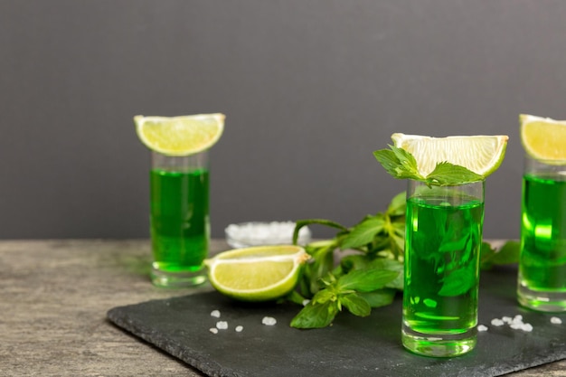 Licor de menta dulce y refrescante con hielo y hojas de menta en el fondo de la mesa.