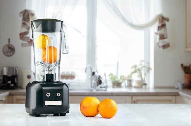 La licuadora eléctrica para hacer jugo de frutas o batidos en la mesa de la cocina. El concepto de una dieta saludable.