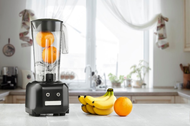 La licuadora eléctrica para hacer jugo de frutas o batidos en la mesa de la cocina de madera. El concepto de una dieta saludable.