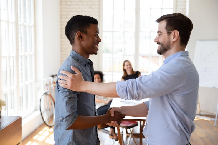 Foto líder de chefe jovem sorridente apertando a mão de um estagiário de etnia africana do milênio, sentindo-se satisfeito com os bons resultados do trabalho, elogiando o sucesso do projeto, concluindo o conceito de motivação