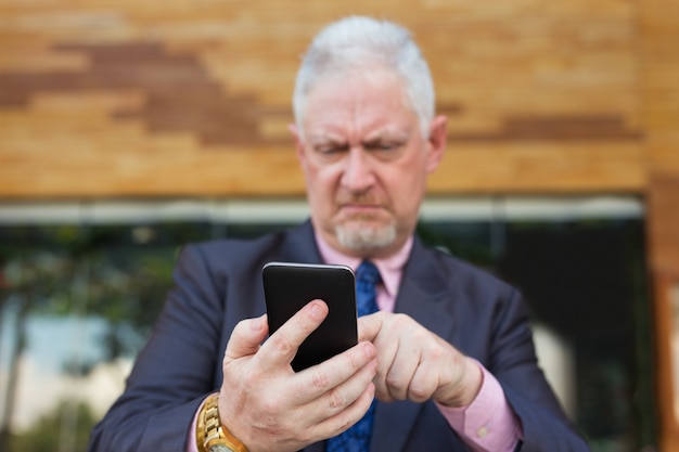 Foto líder empresarial tensado que usa el teléfono inteligente