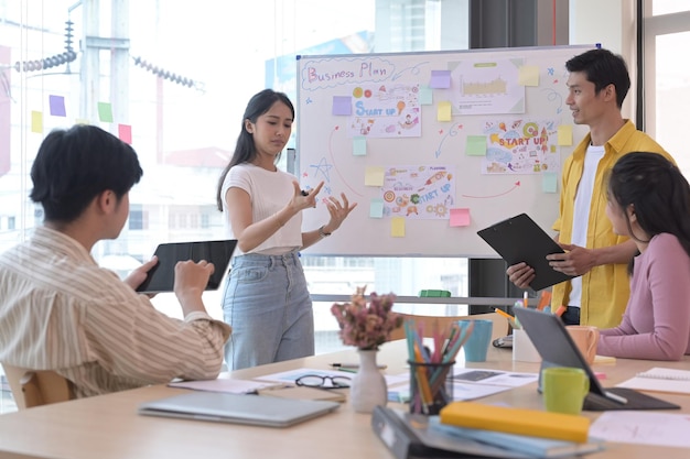 Líder del equipo de negocios que presenta la estrategia de inicio de negocios para diversos empleados en la reunión