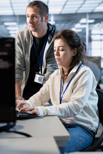 El líder del equipo supervisa la codificación de los empleados en la computadora en la sala de servidores