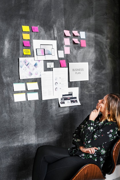 Líder en una lluvia de ideas de una empresa nueva utilizando una pizarra