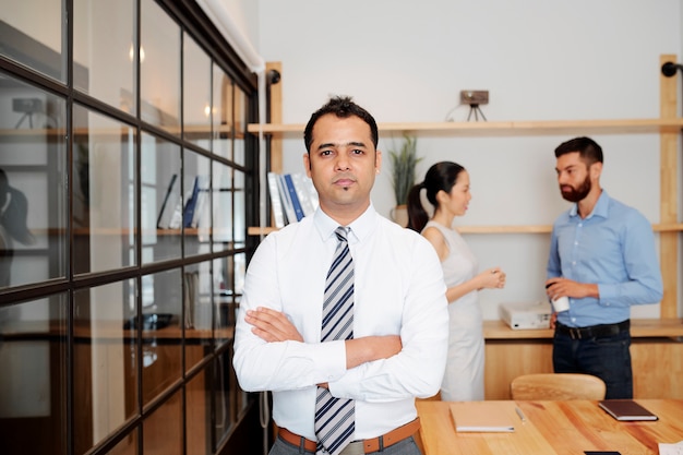 Foto líder masculino indio de pie en la oficina