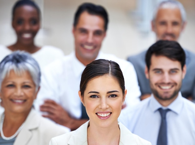 Lidero pelo exemplo Retrato de uma empresária sorridente rodeada por um grupo de colegas