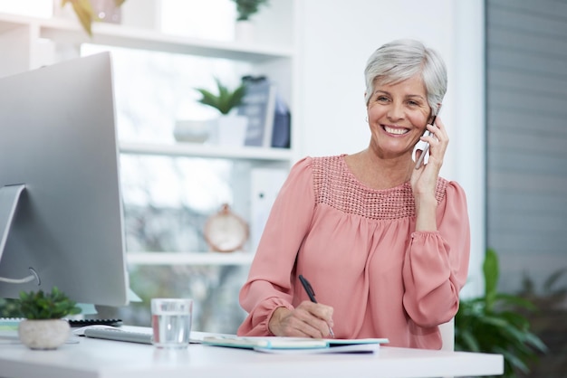 Lidiar con algunas consultas de clientes en la oficina Foto de una mujer de negocios madura tomando una llamada telefónica en su escritorio de oficina en el trabajo