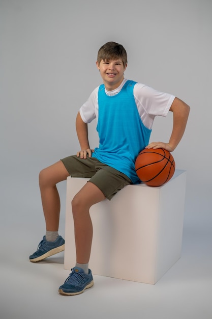 Liebe Backetball. Ein Junge in Sportswear mit Ball in den Händen