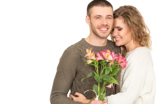 Liebe dich für immer. Studioporträt eines herrlichen liebenden Paares, das mit Blumenstrauß auf weißem Copyspace auf der Seite aufwirft