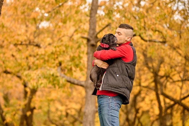 Liebe. Ein Mann steht im Park und umarmt seinen Hund