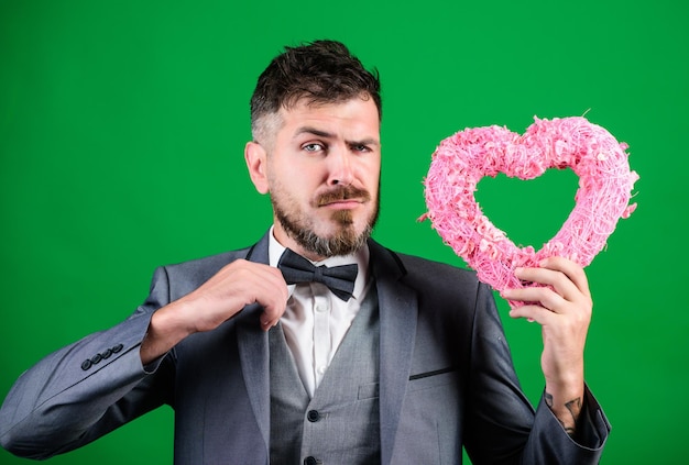 Foto liebe hochzeitstag bärtiger mann im formellen anzug stilvoller ästhet mit dekorativem herz geschäftsmann mit fliege valentinstag urlaub sie sollten es versuchen alles was sie brauchen ist liebe liebe liegt in der luft