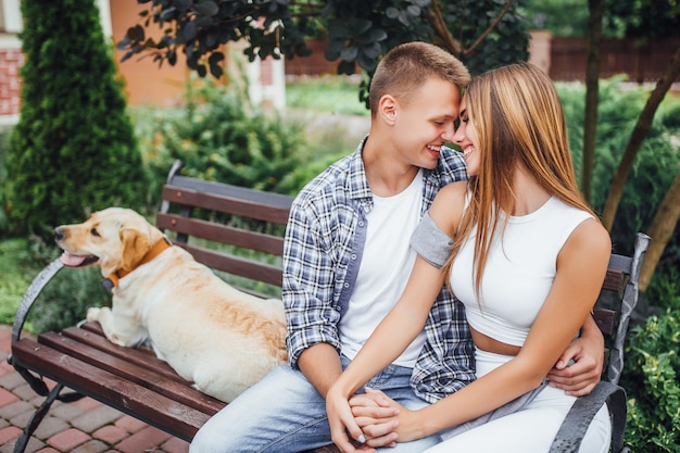 Foto liebe ist alles! junge familie, die ineinander schaut und lächelt. mann und frau ruhen mit ihrem labrador.