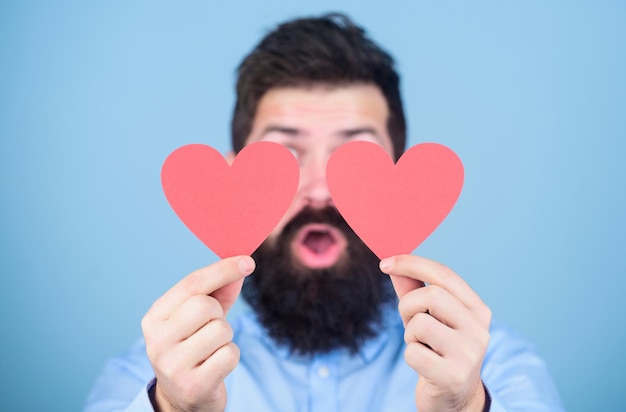 Liebe ist erstaunlich Mann bärtiger Hipster mit Herz-Valentinskarte Feiern Sie die Liebe Kerl attraktiv mit Bart und Schnurrbart in romantischer Stimmung Liebe fühlen Dating- und Beziehungskonzept Glücklich in der Liebe