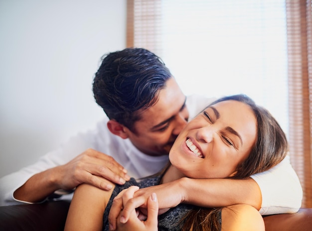 Liebe liegt in der Luft Aufnahme eines lachenden jungen Paares, das zu Hause einen Moment miteinander verbringt