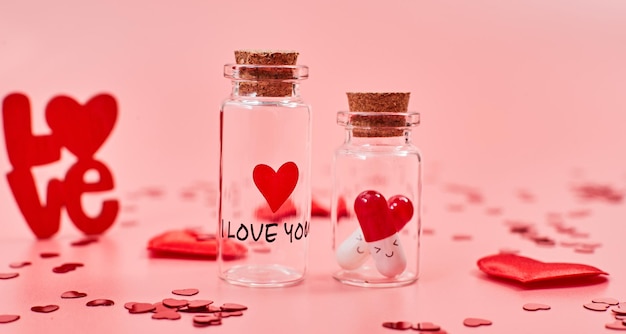 Liebe Medizin. Ich liebe dich. Tabletten in Gläsern küssen den Valentinstag. Liebe Hintergrund. Geschenke in Form von Herzen auf rosa Hintergrund mit der Aufschrift Liebe.