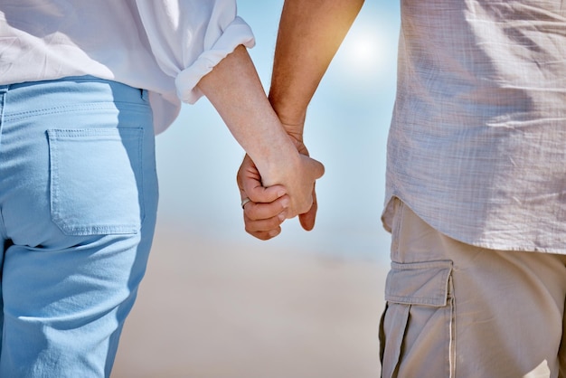 Liebe Sommer und altes Paar Händchen haltend am Strand genießen Meereswellen blauer Himmel und Natur Zuneigung Bindung und liebevoller Mann und Frau unter romantischen Spaziergang auf dem Seeweg im Urlaub und am Wochenende