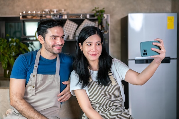 Liebe und romantisches Paar Freund und Freundin Selfie-Foto mit Handy zusammen während des Abendessens kochen für Valentinstagsfeier in der Küche