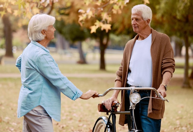 Lieben Sie Fahrrad und Park mit einem älteren Paar bei einem gemeinsamen Date im Sommer, während Sie den Ruhestand genießen Naturdating und Romantik mit einem reifen Mann und einer reifen Frau im Freien in einem Garten für Fahrradbindung