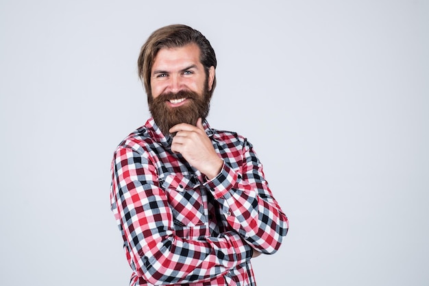 Lieben Sie meinen Stil Schöner bärtiger Mann in Freizeitkleidung lächelnd Fröhlicher kaukasischer Mann brutaler bärtiger Hipster-Mann mit kariertem Hemd lässiger männlicher Mode-Friseursalon