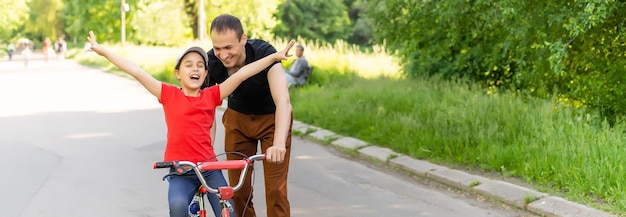 Liebender Vater, der seiner Tochter das Fahrradfahren beibringt.