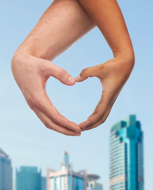 Liebes- und Beziehungskonzept - Nahaufnahme von Frauen- und Mannhänden, die Herzform zeigen