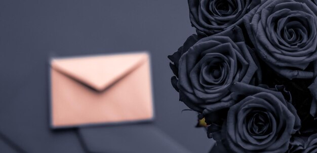 Liebesbrief und Blumenlieferung am Valentinstag Luxusstrauß aus Rosen und Karte auf Holzkohlehintergrund für romantisches Urlaubsdesign