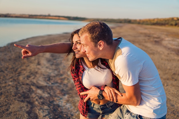 Liebesgeschichte eines jungen schönen Paares am Strand bei Sonnenuntergang