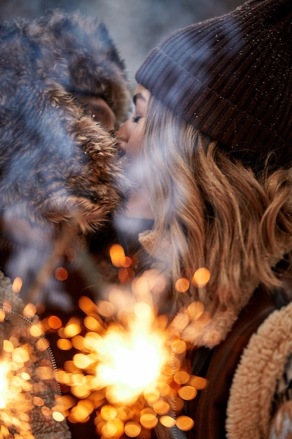Liebesgeschichte eines Paares im Schneewald Küssen und Halten von Wunderkerzen Paar in der Winternatur Paar feiert Valentinstag Datum