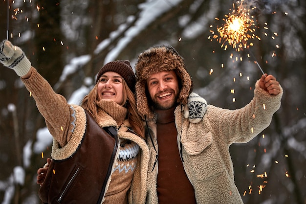 Liebesgeschichte eines Paares im Schneewald Küssen und Halten von Wunderkerzen Paar in der Winternatur Paar feiert Valentinstag Datum