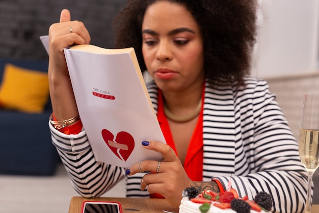 Liebesgeschichte. Selektiver Fokus eines Buches in Händen einer netten afroamerikanischen Frau