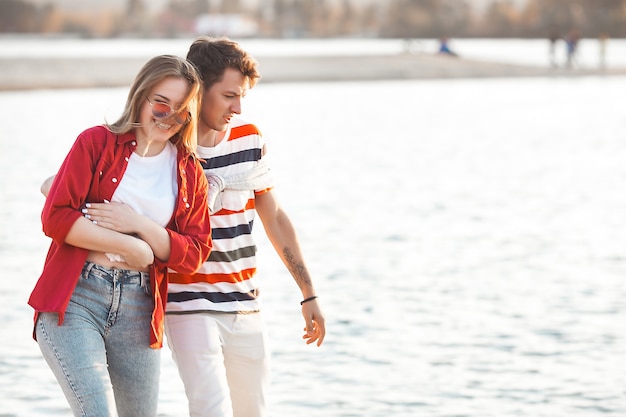 Liebespaar am Sonnenuntergangsstrand. Frau und Mann zusammen