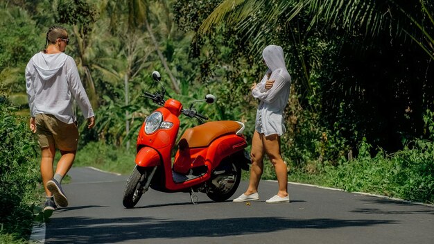 Liebespaar auf rotem Motorrad in weißer Kleidung Sonnenbrille auf Waldweg Trail Trip Tanzende Straße