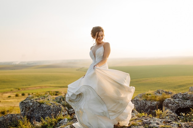 Liebespaar, das jungvermählten draußen bei sonnenuntergang am schönen sommertag heiratet?