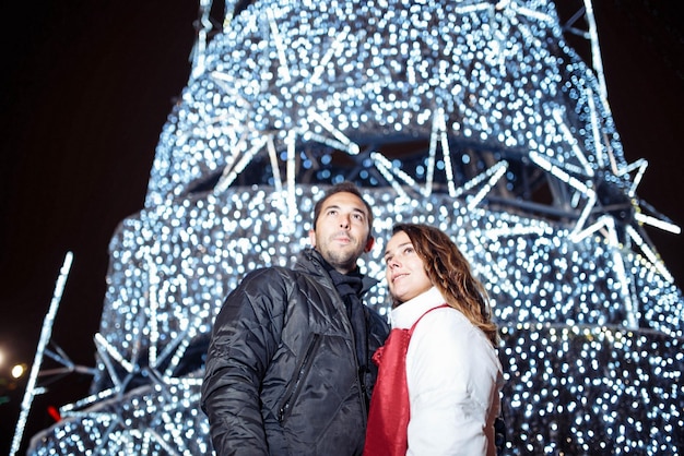 Liebespaar geht im Winter durch die abendliche Weihnachtsstadt.