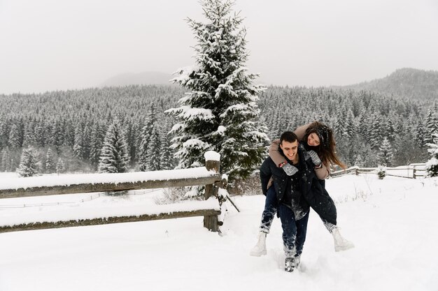 Liebespaar in Daunenjacke auf einem Winterspaziergang. Mann und Frau haben Spaß im frostigen Wald. Romantisches Date im Winter.Weihnachtsstimmung einer jungen Familie.Winter Lovestory