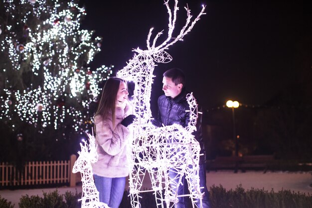 Liebespaar in der Nähe von The Christmas Deer Dekorationen im Freien