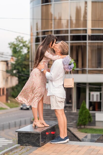 Liebespaar mit Blumen, die durch die Stadt spazieren