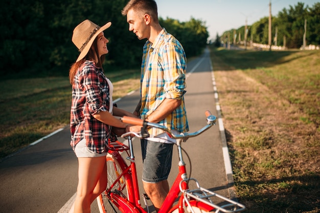 Liebespaar mit Vintage Fahrrad, das im Park geht