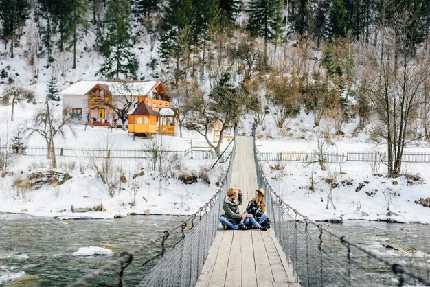 Liebespaar Reisende auf Hängebrücke im Winter in den Bergen.