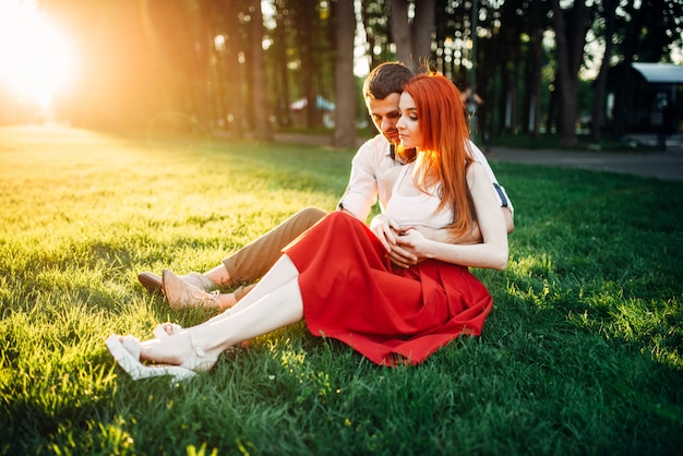 Liebespaar sitzt auf Gras im Park, romantisches Date