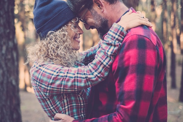 Foto liebespaar und outdoor-natur romantische freizeitbeschäftigung zusammen mann und frau umarmen und miling mit emotionen einander mit wald im hintergrund freude verheiratete lifestyle-menschen