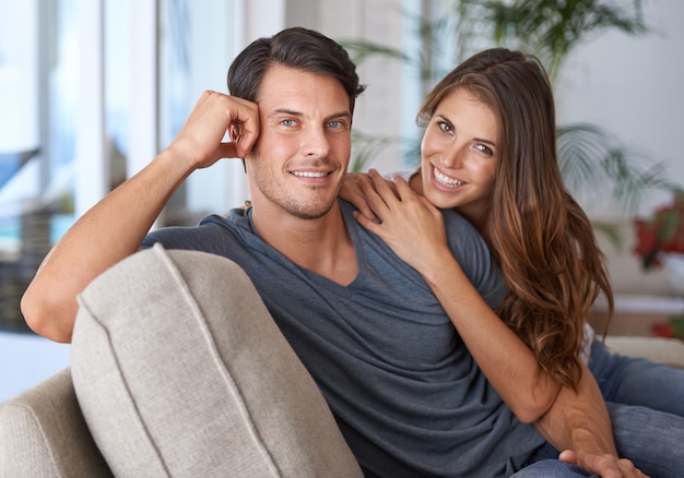 Liebesporträt eines glücklichen Paares, das sich auf dem Sofa im Wohnzimmer seines Hauses verbindet. Ehe oder Beziehung romantisch oder intim und Entspannung oder schöne Zeit zu zweit zu Hause auf der Couch im Wohnzimmer